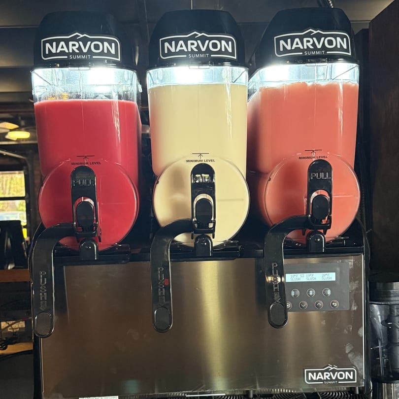 Three Narvon Summit slushie machines filled with red, yellow, and pink frozen drinks.